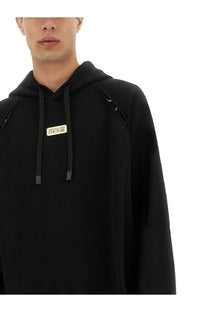 Versace Jeans Couture men’s black hoodie with gold-tone logo patch and matching drawstrings for casual wear