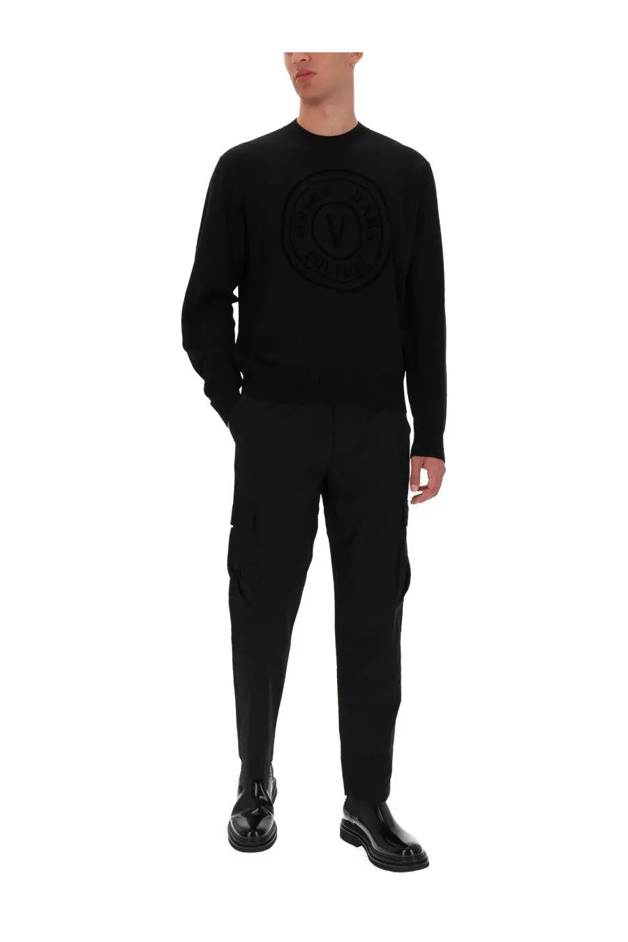 Black knit sweater by Versace Jeans Couture with raised circular logo on chest in jersey material
