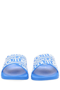 Versace jeans couture men’s blue slide sandals with white repeating logo text across the strap