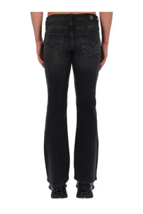 Versace jeans couture men’s black denim flare jeans with subtle distressed finish and back logo patch shown from behind