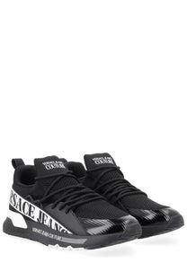 Versace Jeans Couture men’s black sneaker with bold white branding and glossy finish on the toe cap