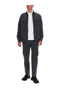 Versace jeans couture men zippered dark gray utility jacket with two chest pockets worn over white polo shirt