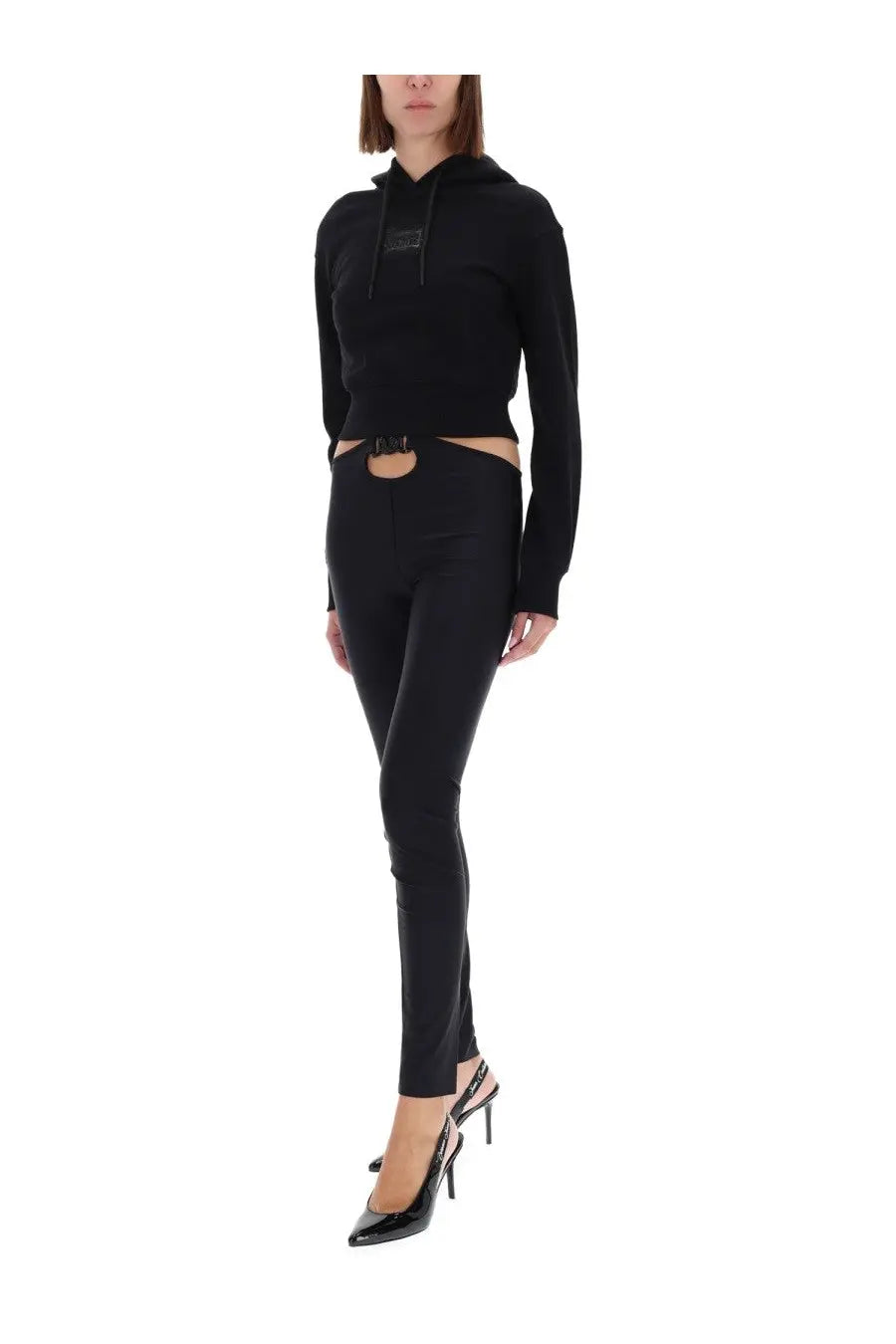 Versace Jeans Couture women’s black cropped hoodie with subtle chest logo paired with high-waisted pants with waist cutout