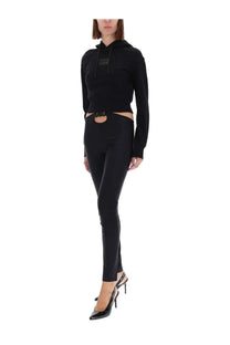 Versace Jeans Couture women’s black cropped hoodie with subtle chest logo paired with high-waisted pants with waist cutout