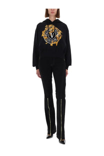Versace Jeans Couture women’s black hoodie with bold gold embroidered logo and matching side zippers on jeans pants