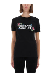 Versace jeans couture women’s black t-shirt with bold white logo and pink blue floral embellishments on front