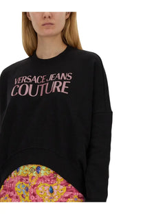 Black oversized versace jeans couture women’s sweatshirt with pink logo print across the chest