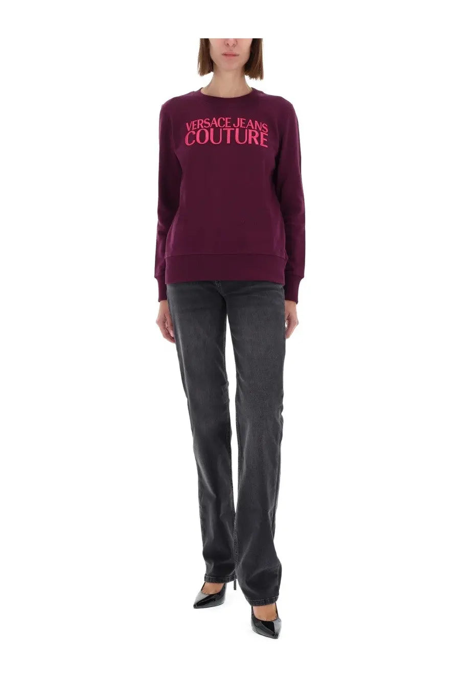 A maroon versace jeans couture womens sweatshirt with bold pink lettering across the chest