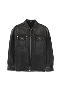 Versace men’s black denim jacket with zipper front, two brass button chest pockets, and rolled cuffs