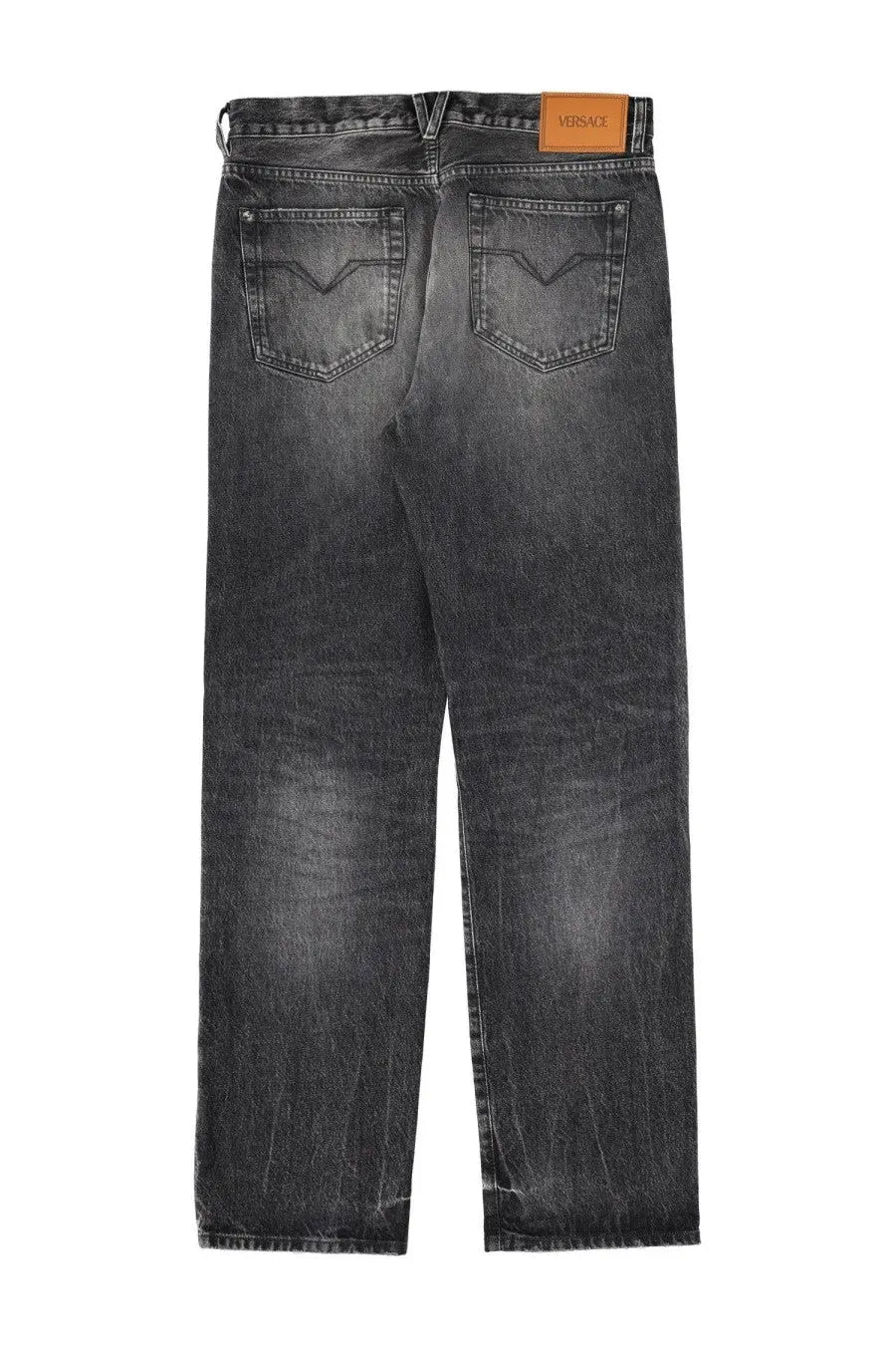 Dark gray distressed denim Versace men’s jeans with a brown leather brand patch at the waistband back side view