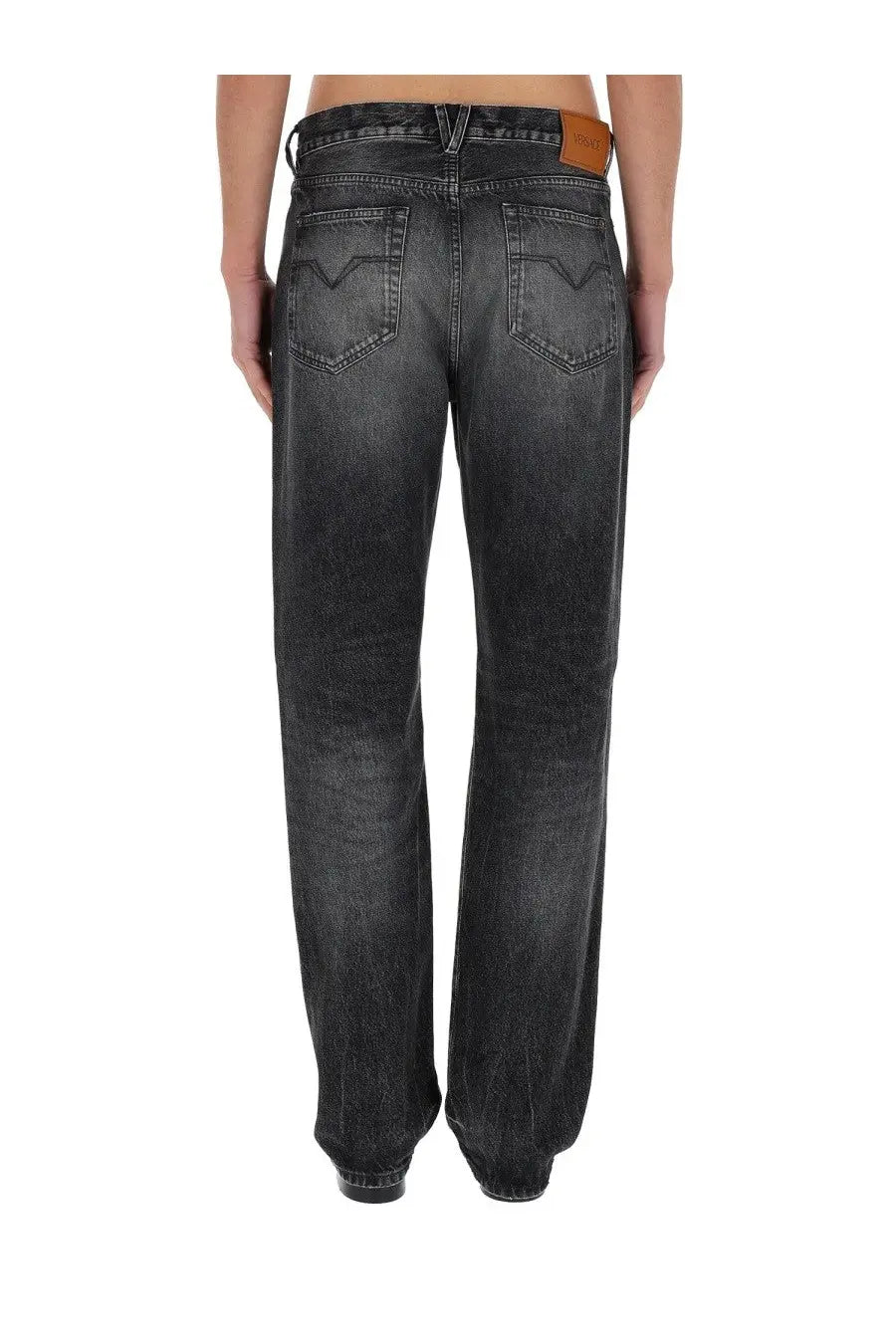 Versace men’s black dark gray washed denim jeans with classic five-pocket design and brown leather waistband patch back view