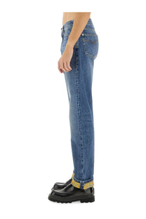 Versace men’s denim blue jeans with faded wash and yellow patterned cuffs in blue denim material