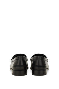 Black leather loafers with a sleek polished finish and classic slip-on design in versace men’s moccasin medusa white