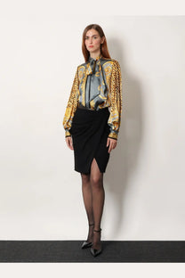 A woman wears a versace women’s cheetah foulard lavallière silk shirt grey with gold and gray baroque pattern and leopard cuffs