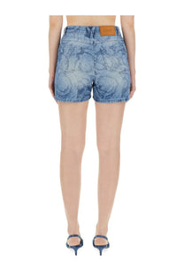 Versace women’s blue denim shorts with a faded swirling pattern and brown leather brand patch at the waistband