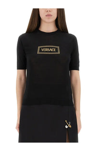 Versace women’s black knit short-sleeved shirt with gold embroidered Versace logo in a rectangular frame