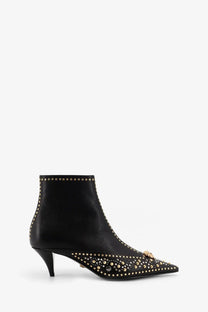 Versace women’s black leather ankle boot with gold tone studs and decorative metallic clasp at the toe