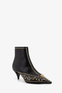 Versace women’s black leather ankle boots with gold-tone studs and Medusa head emblem at the toe