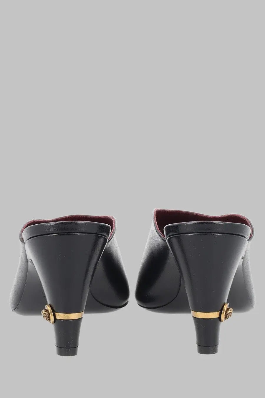 Back view of versace women’s black leather mule giulietta with gold-tone medusa head embellishments on heels