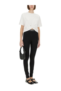 Black textured handbag with metallic logo and structured design paired with versace women’s re edition safety pin shirt white