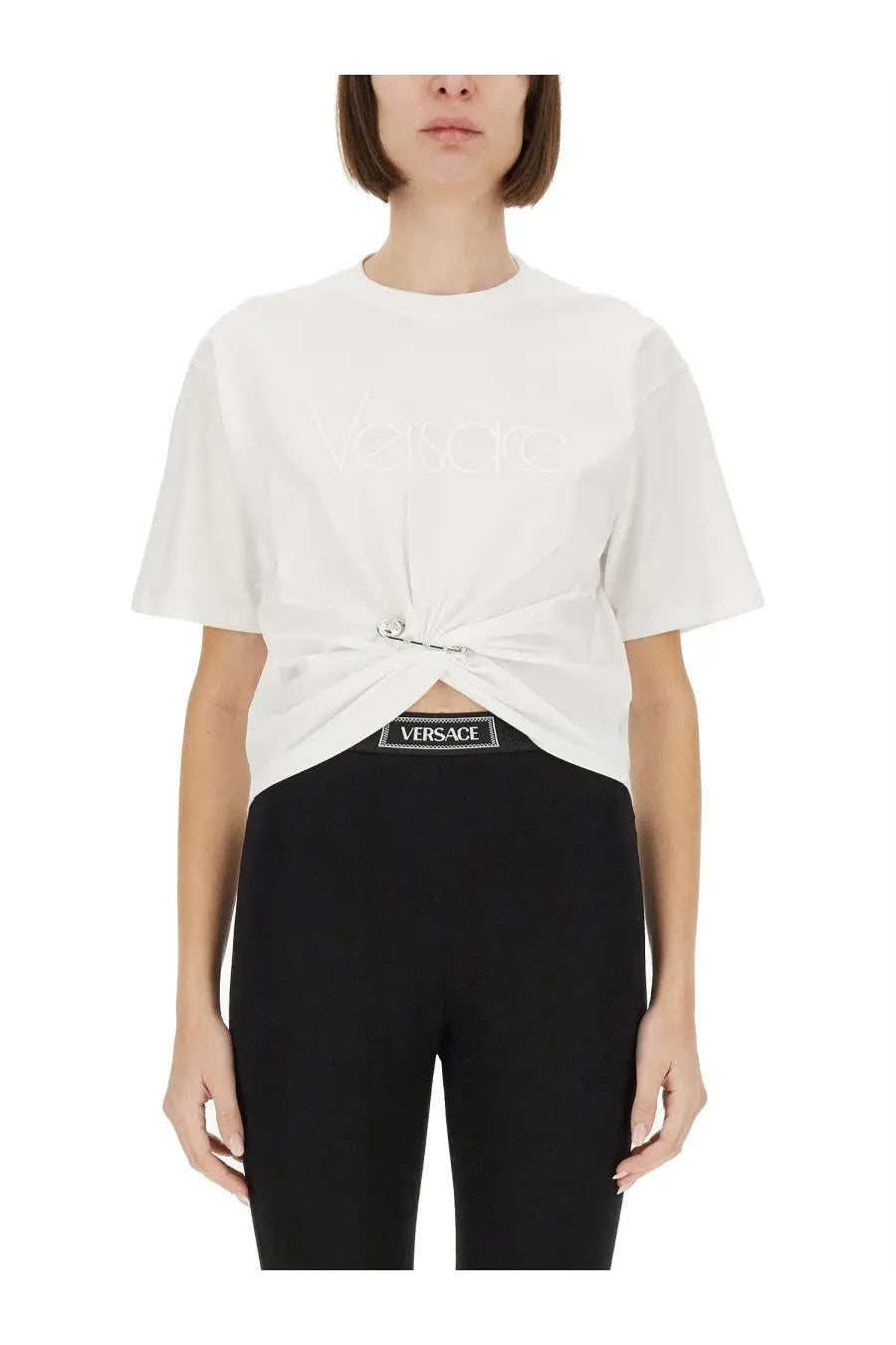 Versace women’s white t-shirt with subtle embossed logo and knotted front detail from the RE Edition Safety Pin collection