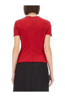 Back view of versace womens red short sleeved top with a central zipper and safety pin curled detail