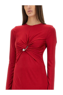 A vibrant red versace women’s midi dress with long sleeves twisted front detail and silver safety pin accent