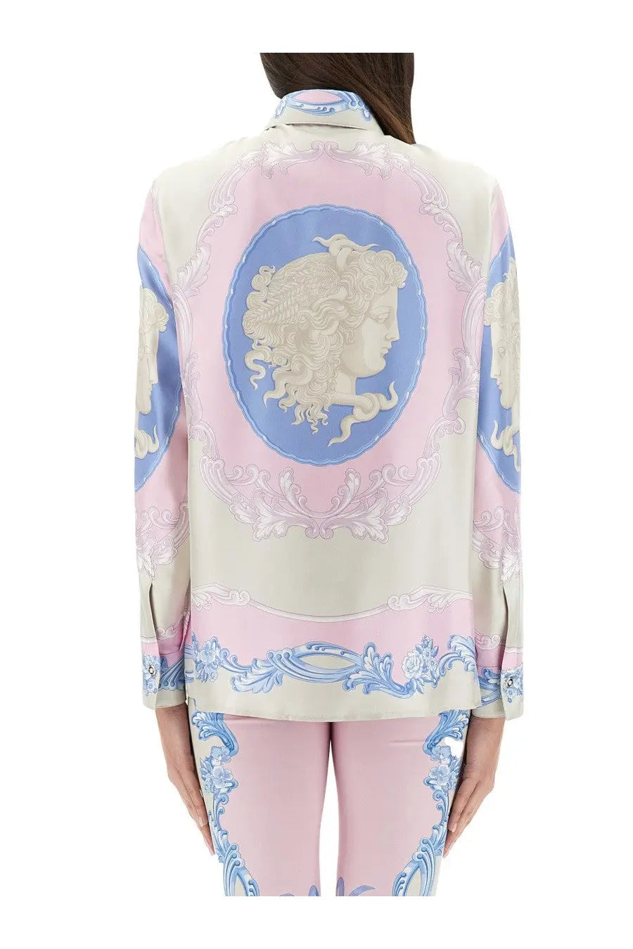 A woman wearing a Versace women’s silk shirt cameo blue with elegant pink and blue classical portrait print