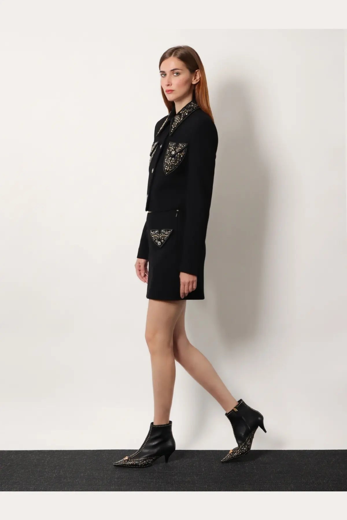 Black blazer with intricate silver embellishments on collar and pockets paired with versace women’s virgin wool mini skirt black