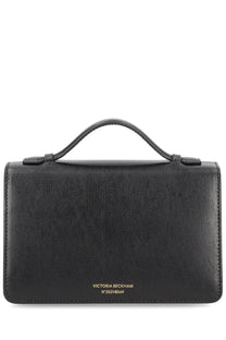 Black leather victoria beckham dorian small handbag with top handle and gold tone branding at the bottom