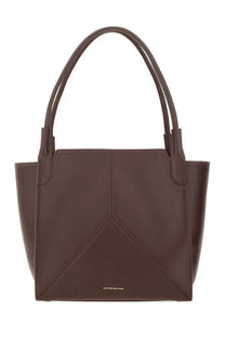 Victoria Beckham women’s borsa tote victoria red is a sleek dark brown leather tote bag with geometric design and dual handles