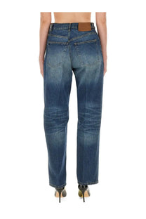 Back side of victoria beckham women’s boyfriend jeans in medium blue denim with subtle fading and brown leather patch