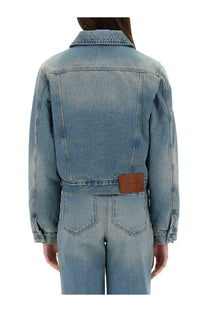 Victoria Beckham women’s blue light-wash denim jacket with classic collar and brown leather patch at the waist