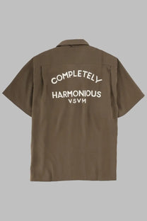 Visvim men’s brown short-sleeved button-up shirt showing white embroidered text on the back