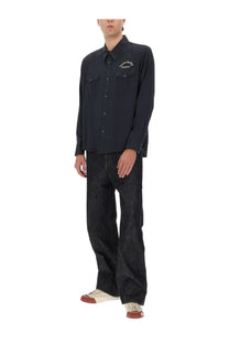 Visvim men’s black long-sleeved button-up shirt with two chest pockets and subtle embroidered logo on left side