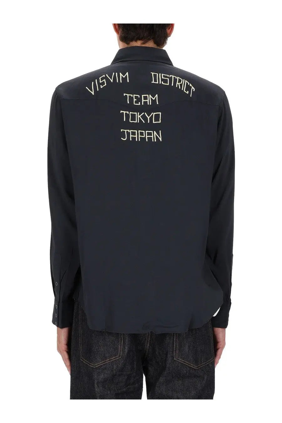 Back view of visvim men’s four corners black long-sleeved shirt with white embroidered text on cotton fabric