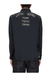 Back view of visvim men’s four corners black long-sleeved shirt with white embroidered text on cotton fabric