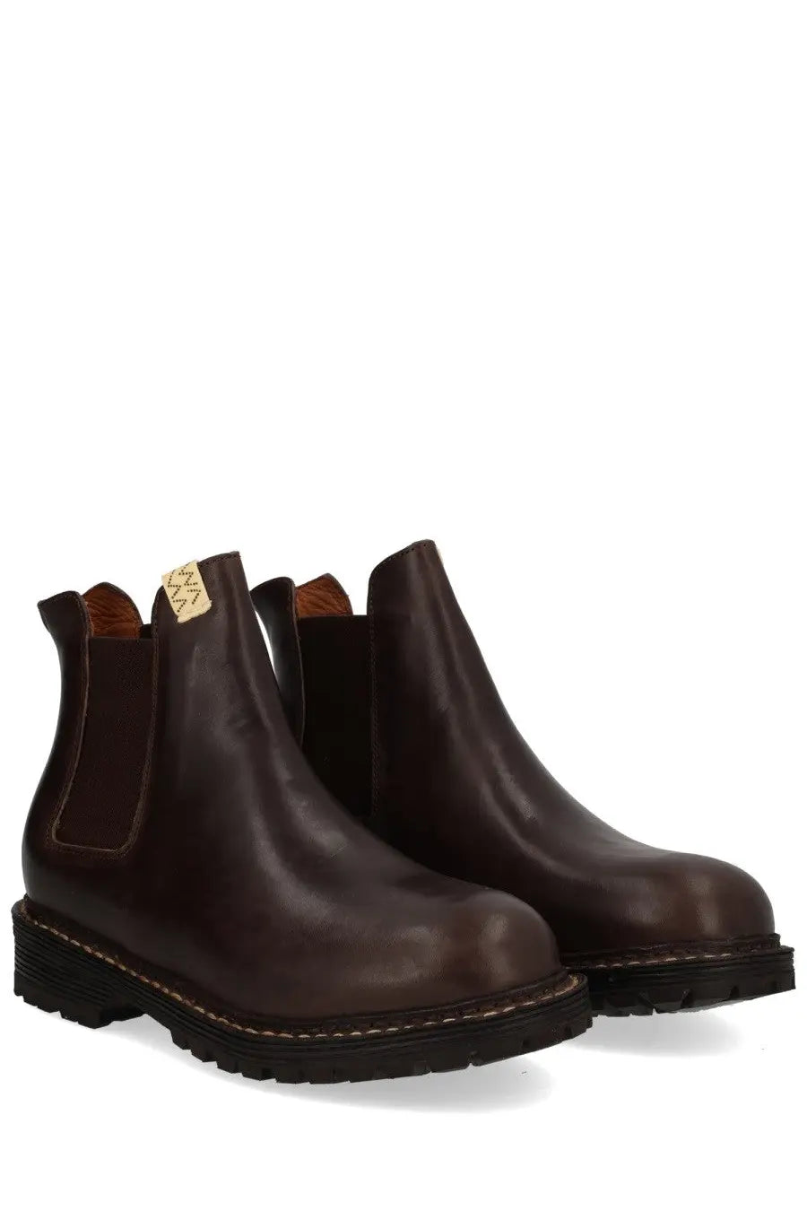 Visvim men’s dark brown leather chelsea boots with rugged rubber sole and visible stitching along the edge