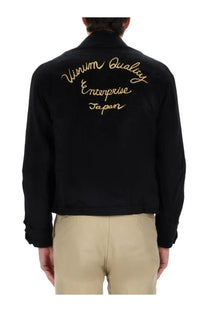Back view of visvim men’s norad blouson black bomber jacket with gold embroidered vitamin quality enterprise japan text