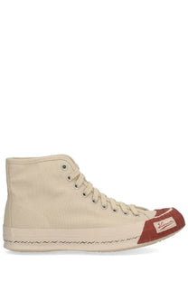 Beige canvas visvim men’s skagway hi sneaker with red toe cap and zigzag stitching along the sole