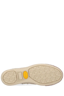 Beige rubber sole with yellow vibram logo and textured tread pattern on visvim men’s skagway hi sneaker white