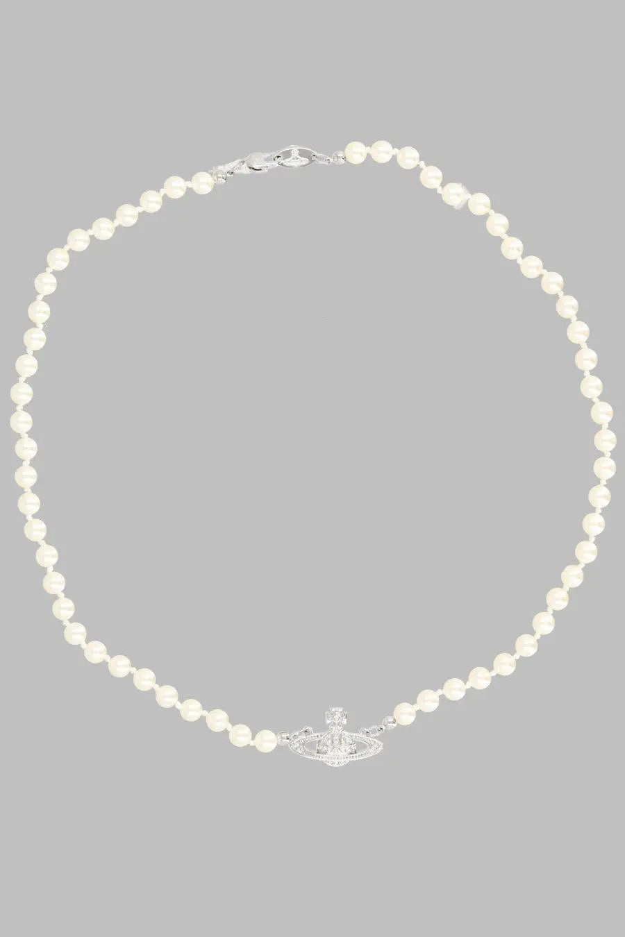 A delicate white pearl necklace with a silver vivienne westwood orb pendant in basso rilievo silver