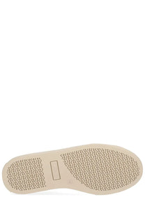 Beige rubber sole with herringbone tread and rectangular brand label on vivienne westwood women’s white low top plimsoll sneaker