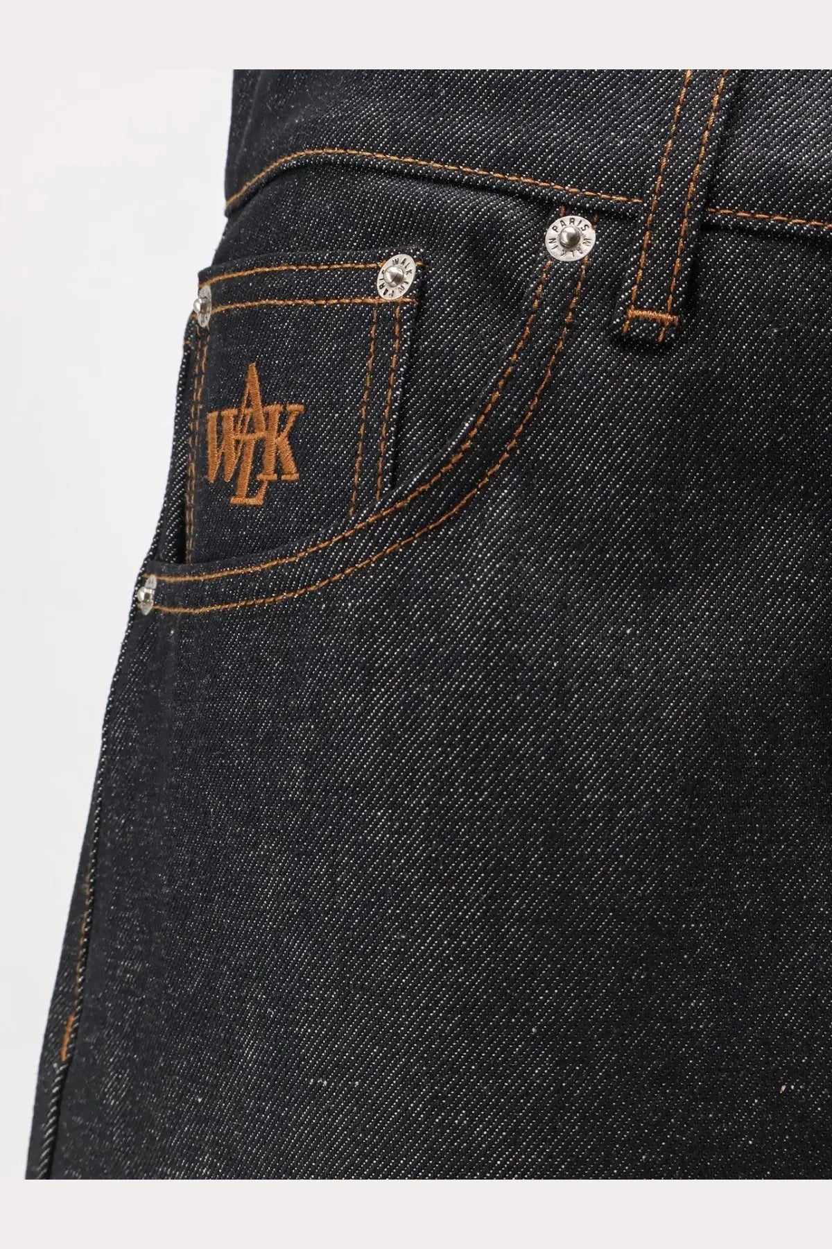 Back side of walk in paris men’s baggy blue denim jeans in dark blue with brown embroidered logo and silver rivets