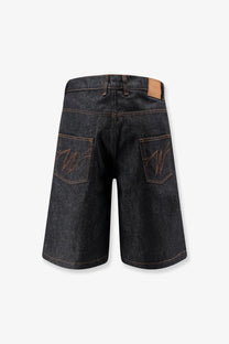 Back side of walk in paris men’s baggy raw denim shorts in dark blue with embroidered w logo on each pocket