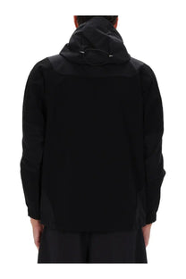 And wander men’s black hooded jacket with sleek modern design and subtle paneling, front view