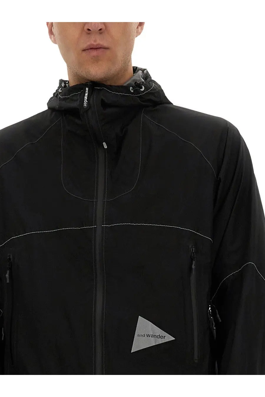 And wander men’s ul jacket black waterproof with subtle white stitching and triangular logo patch on the chest