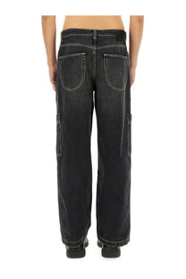 Off-White men’s black denim cargo jeans with white stitching and side pockets visible from the front side