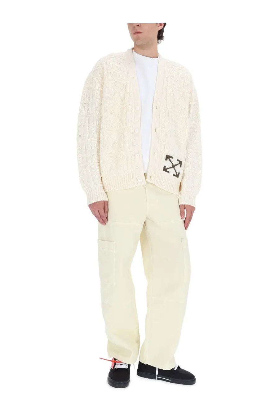 Cream-colored cable knit cardigan with black arrow logo on left chest paired with off-white men’s beige cargo pants