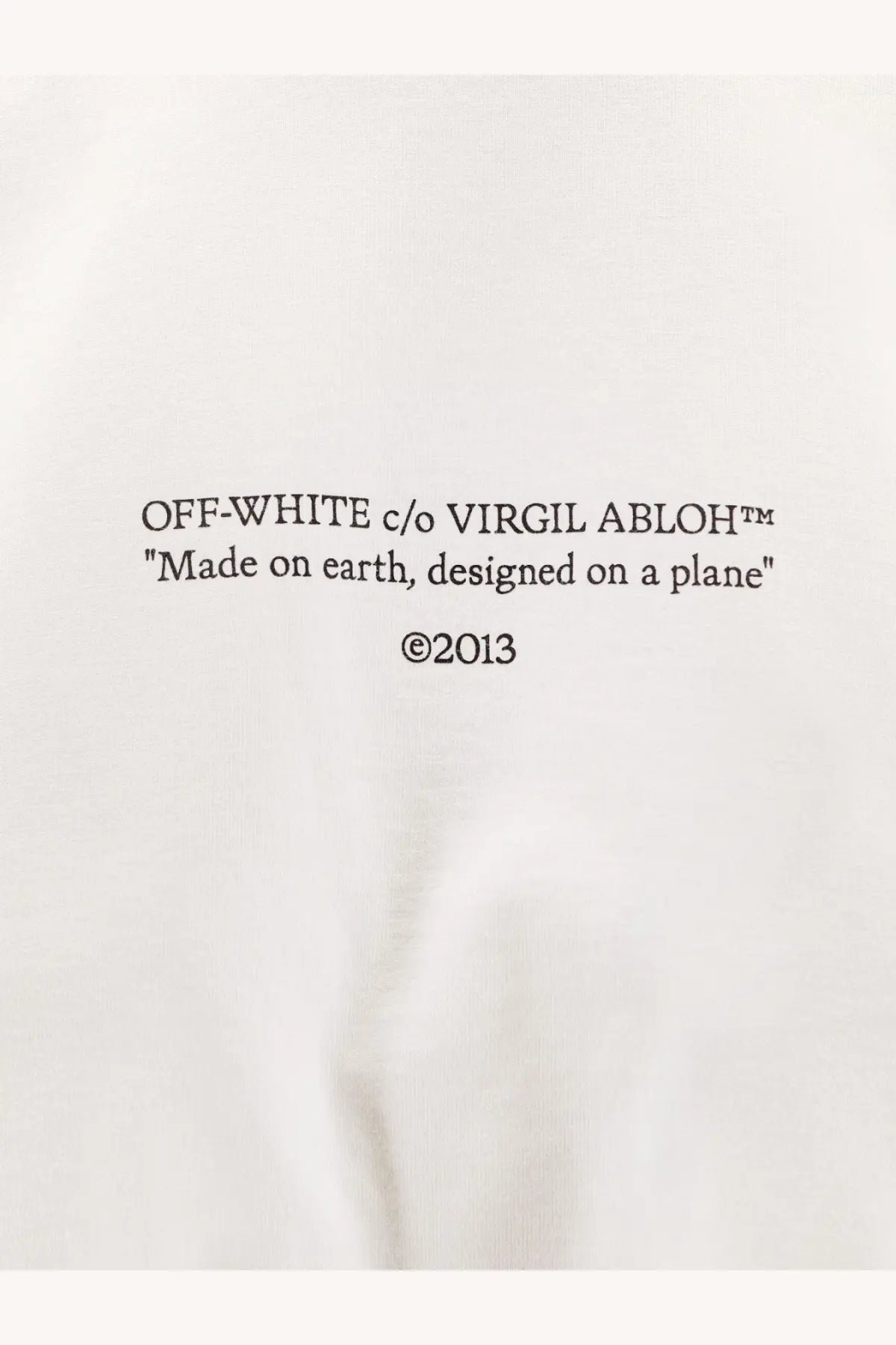 Off-white women’s white cotton sweatshirt with black text made on earth designed on a plane copyright 2013